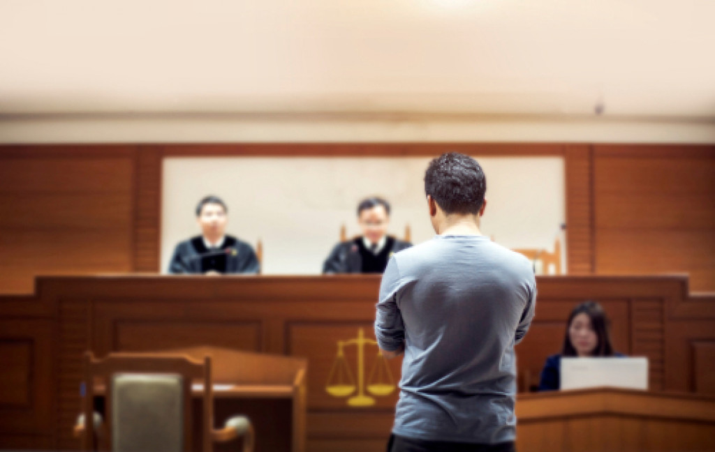 A man standing before a judge in court