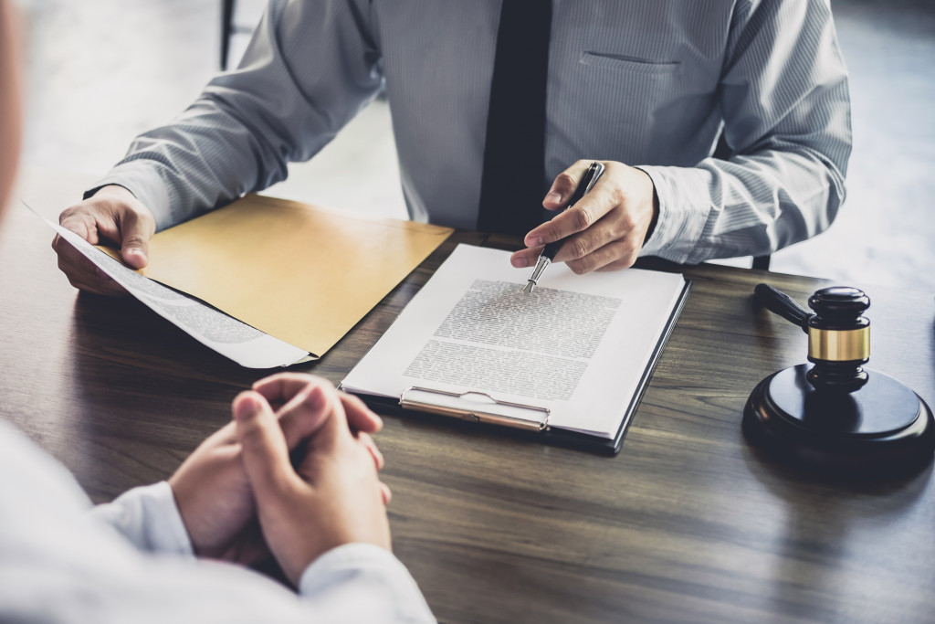 male lawyer talking to male client reviewing documents with gavel on the side