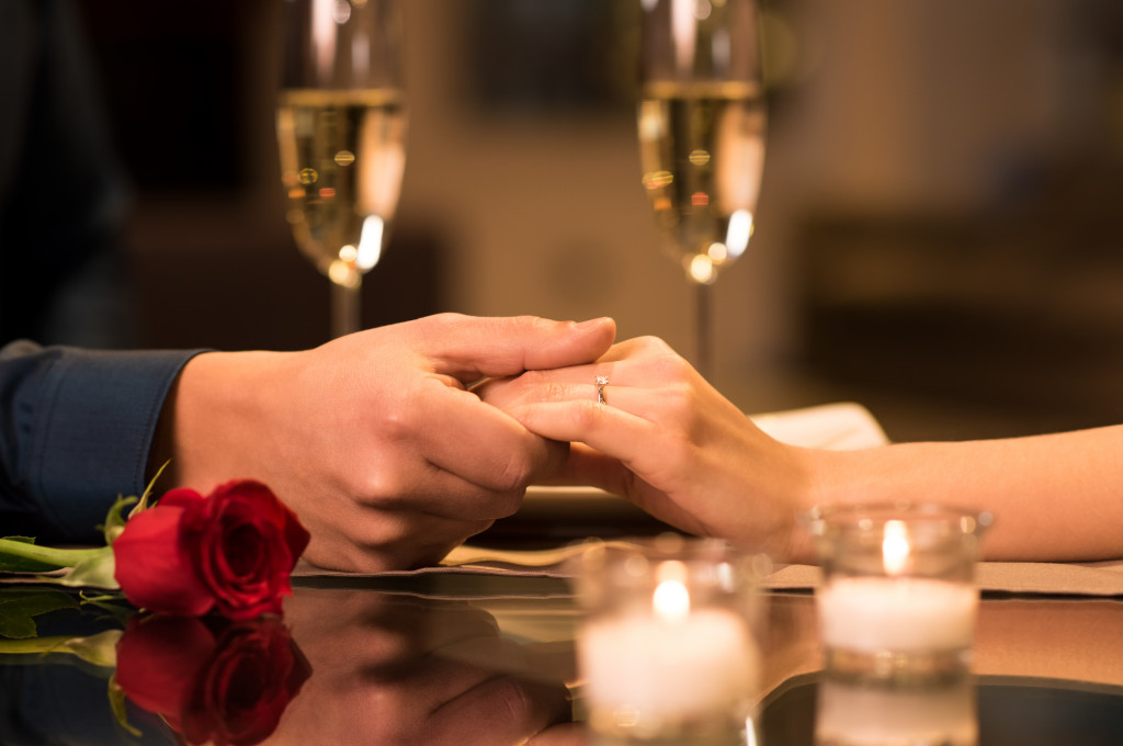 Married couple having dinner and holding hands